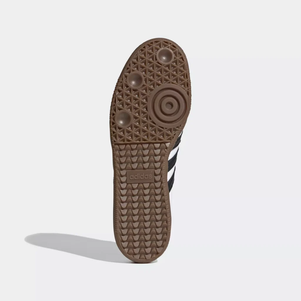 A close-up of Adidas GORE-TEX waterproof sneakers in an urban setting, showing their durable sole, sleek design, and water-resistant material.